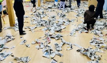 新聞を破いて遊ぶ楽しそうな子供